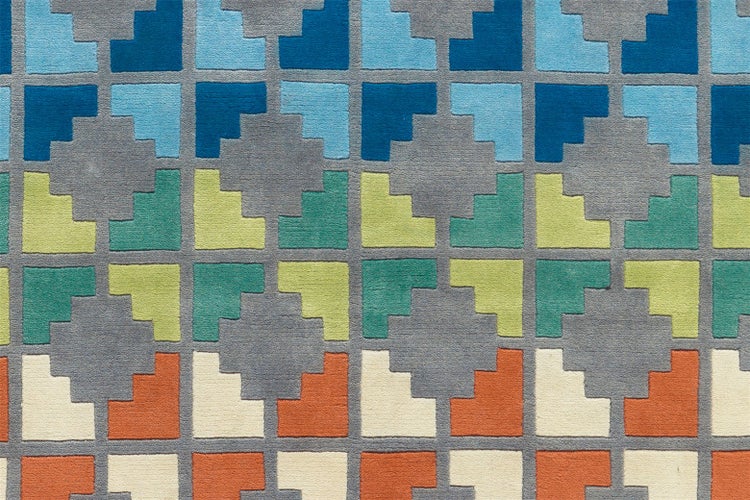 Kurzflor-Teppich mit buntem geometrischem Stufenmuster.