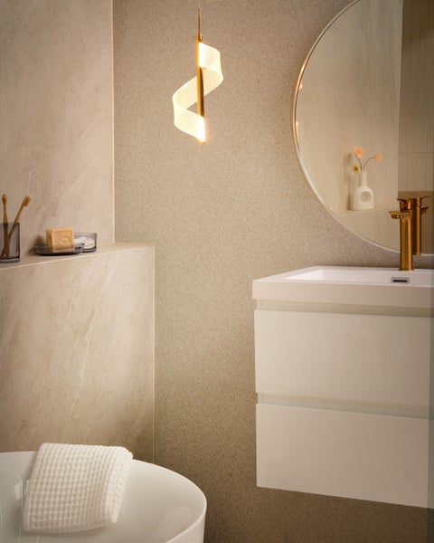 Badezimmer mit Waschtisch, Spiegel, Handtuch und spiralförmiger Pendelleuchte