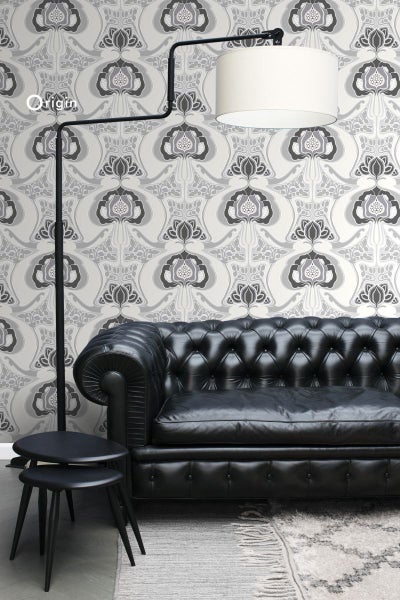 Wohnzimmer mit gemusterter Tapete, Sofa, Stehlampe und Beistelltischen