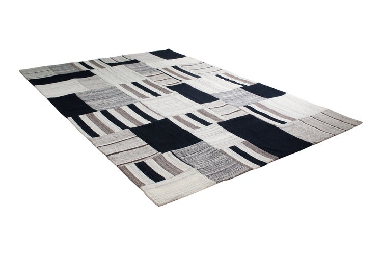 Rechteckiger Webteppich mit geometrischem Patchwork-Muster und Streifen-Design.