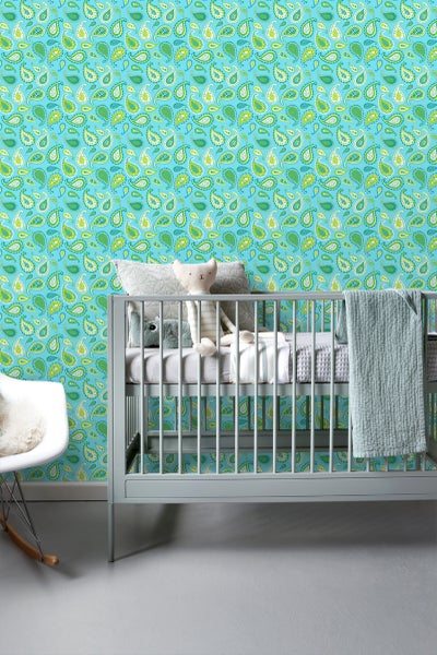 Dekoratives Kinderzimmer mit einer Wandtapete mit Paisleymuster, einem Kinderbett, einem Stuhl und einem Stofftier.