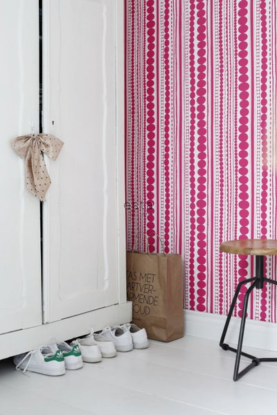 Dekorativer Raum mit Mustertapete, Tür, Schuhen und Hocker