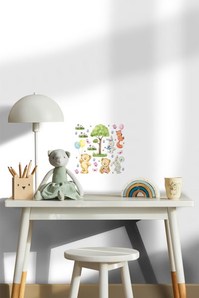 Kinderzimmer mit Schreibtisch, Stuhl, Lampe, Buntstifthalter, Stofftier, Holzregenbogen und Wandtattoo mit Waldtieren