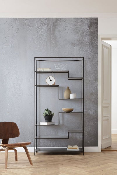 Schwarzes Metallregal mit dekorativen Elementen in einem modernen Raum.