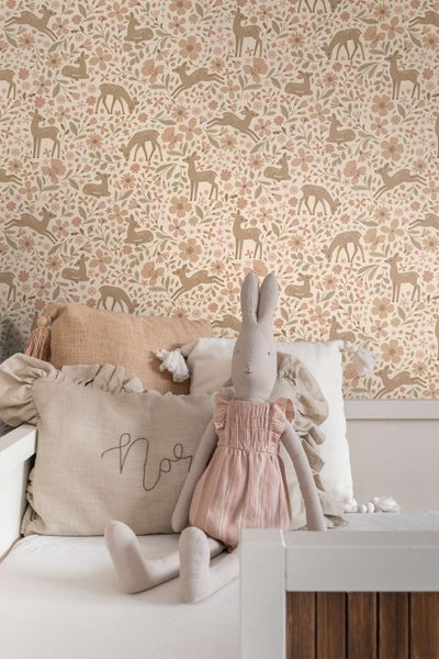 Tapete mit Reh und Blumenmotiv in einem Kinderzimmer mit weichen Textilien und Kuscheltier