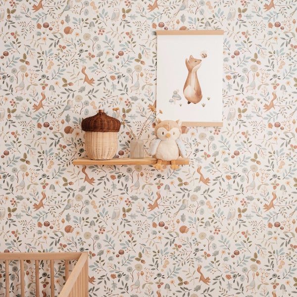 Tapete mit Waldmotiven wie Eichhörnchen, Vögeln und Pflanzen in einem Kinderzimmer mit Wandregal und Dekoration.