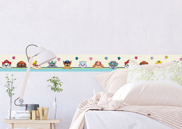 Wandbordüre mit Paw Patrol Motiven in einem hellen Kinderzimmer über einem Bett.