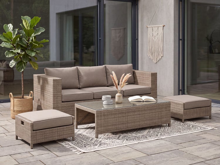 Modernes Lounge Set mit Sofa, zwei Hockern und einem Couchtisch mit Glasplatte auf einer Terrasse, ergänzt durch eine Pflanze und ein Makramee.
