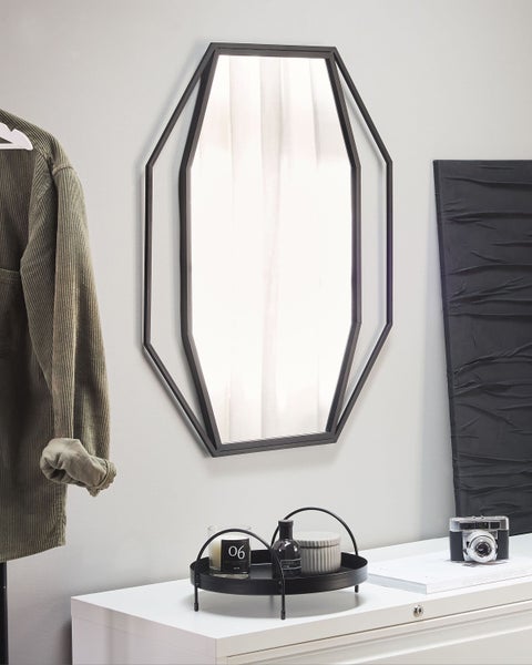 Detailansicht eines Spiegels mit einem Rahmen aus Rattan.