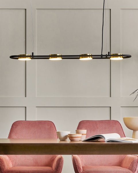 Moderne Hängelampe aus Metall über einem Esstisch mit Stühlen