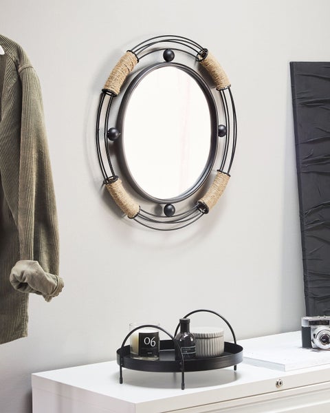 Dekoratives Interieur mit Spiegel, Dekoschale, Kerze, Duftflasche und Vintage Kamera auf Kommode