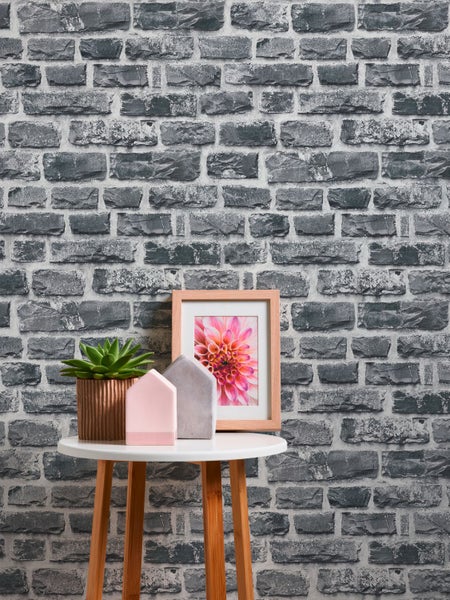 Wandgestaltung mit grauer Steinoptik-Tapete, Schreibtisch und Dekoration