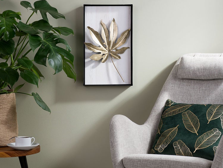 Dekoratives Wohnambiente mit Zimmerpflanze, Kissen und Wandbild