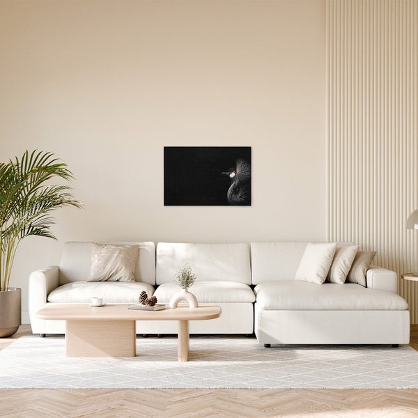 Wohnzimmer mit Sofa, Tisch und einem Bild eines Graukronenkranichs