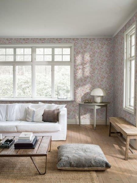 Helles Schlafzimmer mit Bett, Nachttisch, Teppich und Tapete mit Blumenmuster