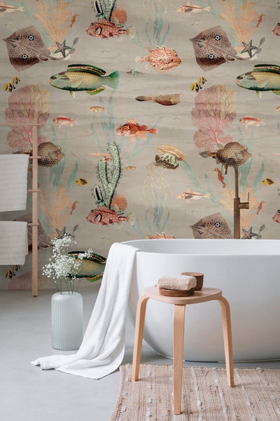 Modernes Badezimmer mit weißer freistehender Badewanne und Tapete mit Meeresmotiven wie Fischen, Rochen und Korallen im Vintage-Stil.