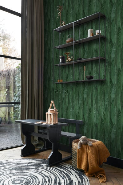 Wohnzimmer mit grüner Tapete, Regal, Tisch und Teppich