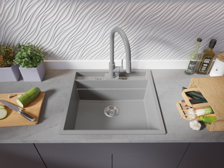 Graue Küchenspüle mit Armatur, Gemüse und Küchenutensilien auf der Arbeitsplatte