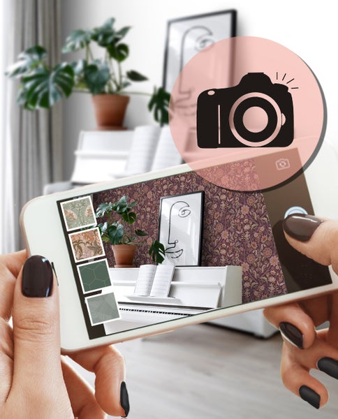 Dekoratives Interieur mit gemusterter Tapete, Tischlampe und Kerzenständer auf einem Holztisch