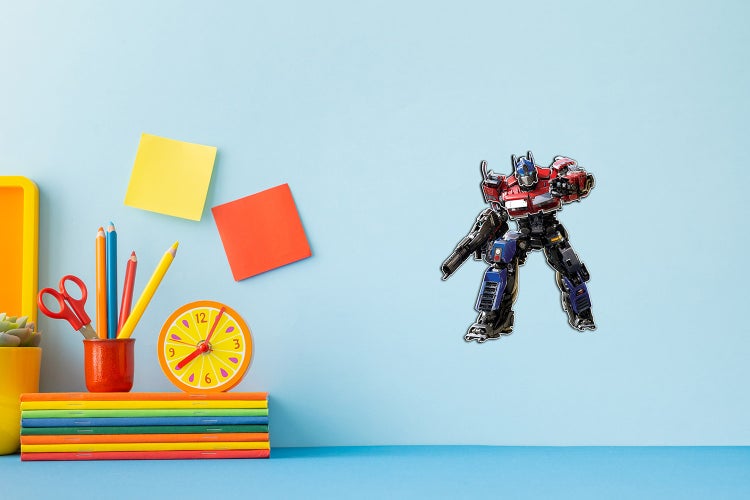 Transformers Optimus Prime Wandsticker in einem hellen Kinderzimmer mit Schreibtischzubehör wie Notizbüchern und Stiften.