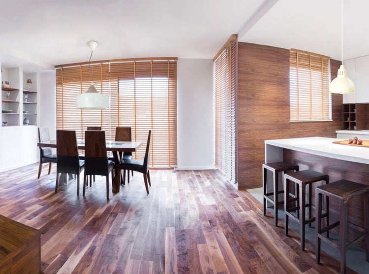 Heller Wohnraum mit Esstisch, Stühlen, Holzjalousien und Parkettboden