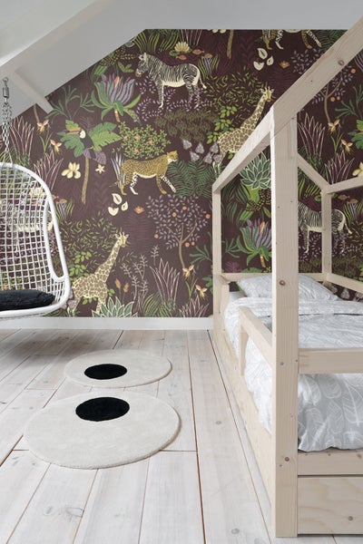 Kinderzimmer mit Holzbett, Hängesessel und gemusterter Tapete