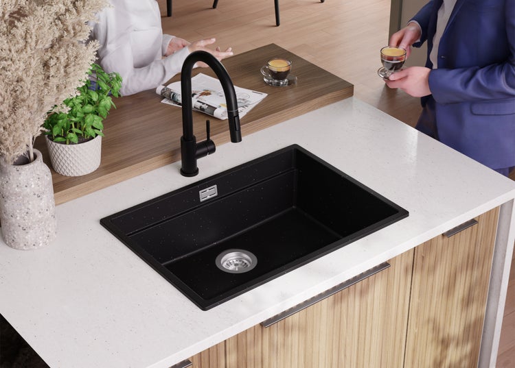 Schwarzes Spülbecken mit Wasserhahn in einer modernen Küchenumgebung.