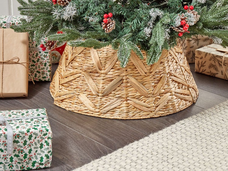 Dekorierter Weihnachtsbaum mit geflochtenem Baumständer und Geschenken