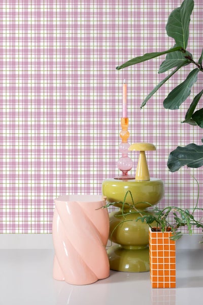 Dekoratives Interieur mit karierter Tapete, Beistelltisch, Kerze und Zimmerpflanze