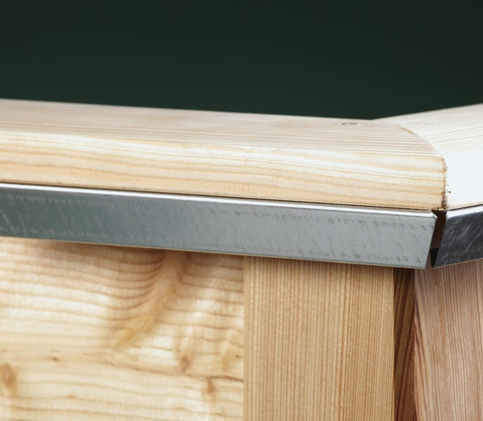 Detailansicht von einem Hochbeet aus Holz mit integriertem Kantenschutz aus Metall.