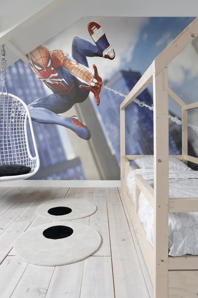 Helles Kinderzimmer mit Spiderman-Wandbild, Schaukelstuhl, Hochbett und zwei runden Teppichen