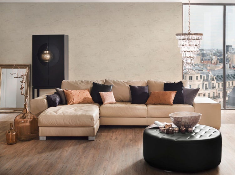 Wohnzimmer mit beiger Tapete, Sofa, Kissen, Decke und Beistelltisch mit London-Bild