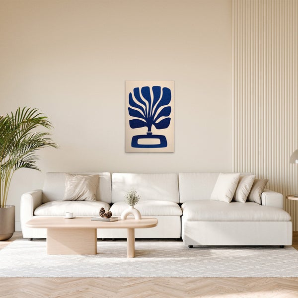 Wohnzimmer mit Sofa, Tisch und einem Wandbild mit einem Pflanzenmotiv.