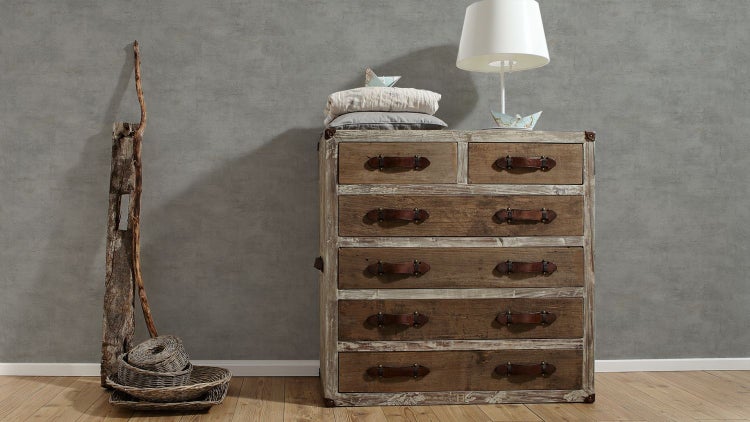 Wohnzimmer mit Ecksofa, Pouf und dekorativen Elementen