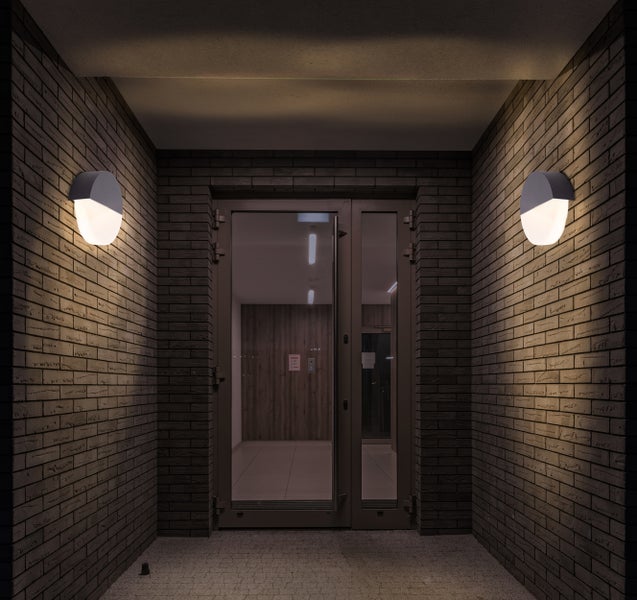 Eingangsbereich mit zwei Wandleuchten und einer Glastür