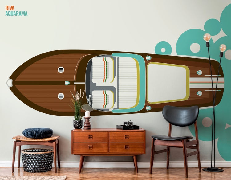 Wandtattoo Riva Aquarama in einem hellen Wohnzimmer mit Retro-Holzmöbeln, Sideboard und Stuhl vor einer Wand mit grafischen Mustern.