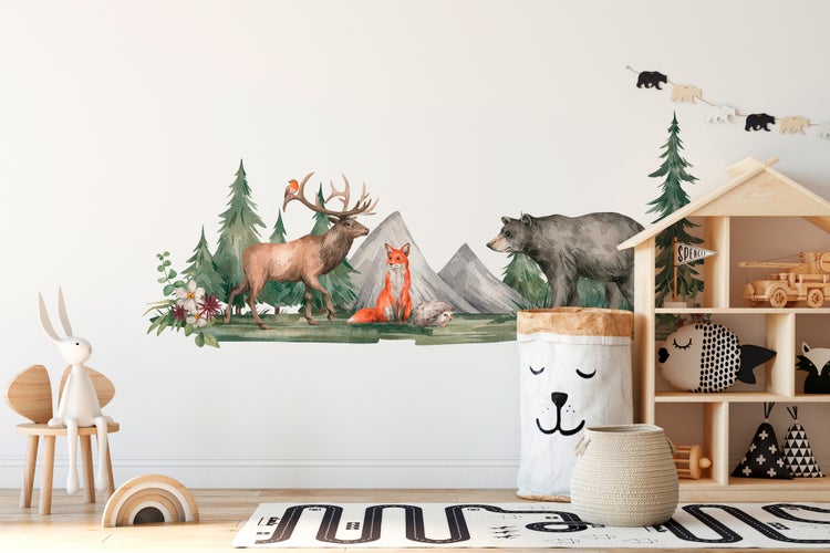 Wandtattoo Waldtiere mit Hirsch, Fuchs, Bär, Bergen und Tannen im hellen Kinderzimmer mit Holzregal und Spielzeug.