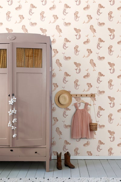 Szene mit Spielzeug auf einem Schrank vor einer Wand mit Meerjungfrauen-Motiv