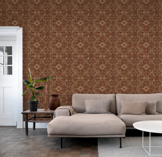 Wohnzimmer mit gemusterter Tapete, Sofa und Zimmerpflanze auf einem Beistelltisch