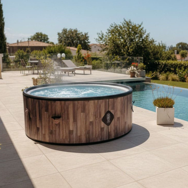 Runder Whirlpool in Holzoptik auf einer hellen und organisierten Terrasse neben einem Swimmingpool im Garten.