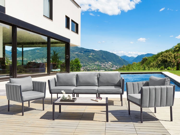 Gartensitzgruppe mit Sofa, Sesseln und Tisch auf einer Terrasse mit Pool und Landschaft