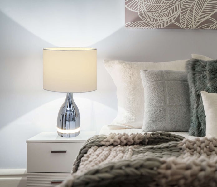 Dekorative Nachttischlampe aus Chrom neben einem Bett