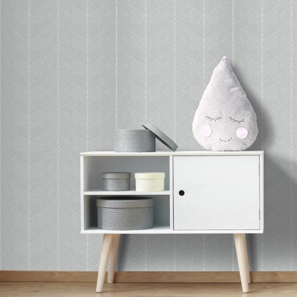 Vliestapete mit feinem Fischgrät-Muster in einem hellen Kinderzimmer mit weißem Sideboard und Aufbewahrungsboxen.