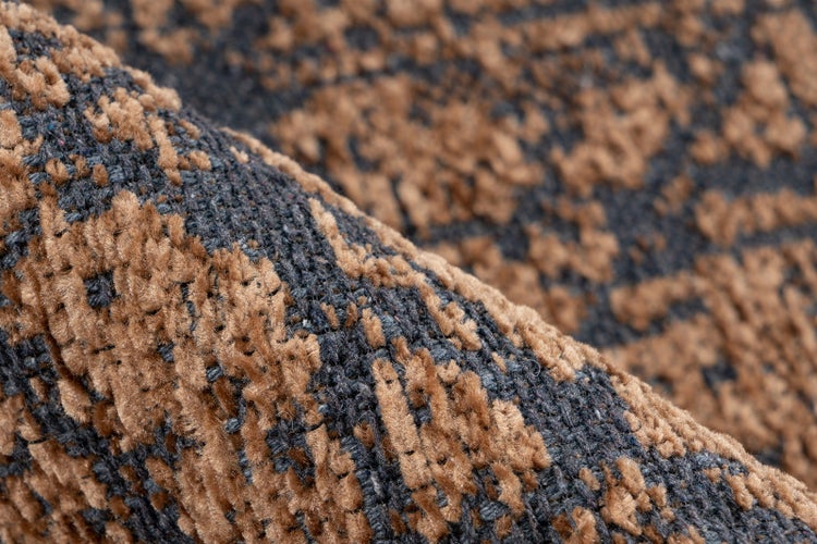 Nahaufnahme der Textur eines gewebten Teppichs mit braunem und grauem Muster.