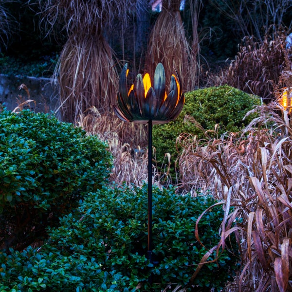 Dekorative Gartenleuchte in Form einer Lotusblume, die nachts den Garten beleuchtet