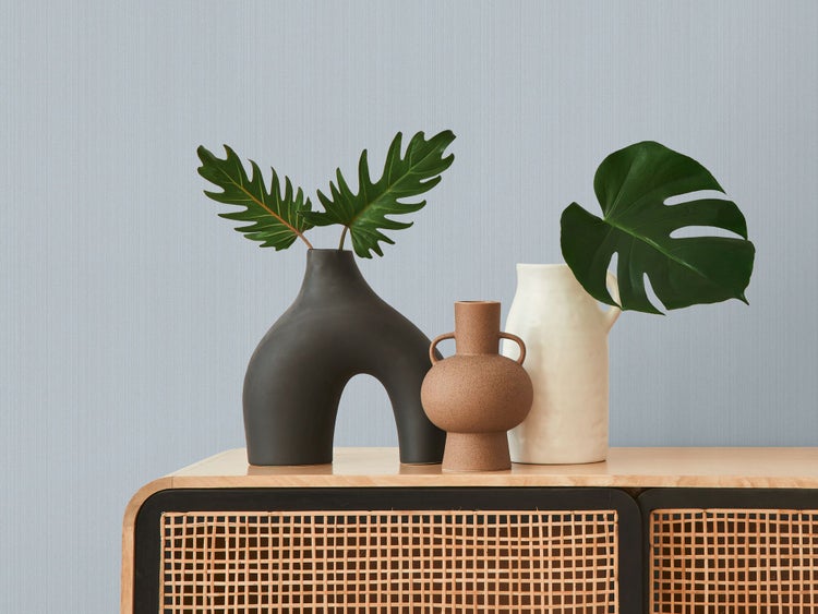 Interieuransicht mit Zimmerpflanze, Schallplattenspieler und Holzkommode