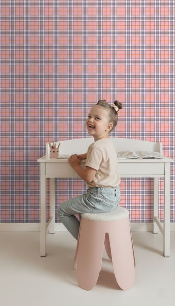 Vliestapete mit Karomuster in einem hellen Kinderzimmer mit Schreibtisch und sitzendem Kind.