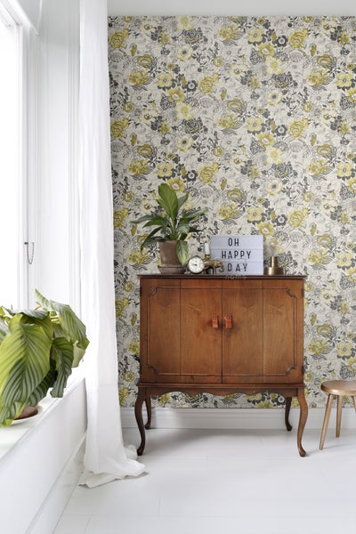 Retro-Raumansicht mit geblümter Tapete, Holzschrank und Zimmerpflanzen