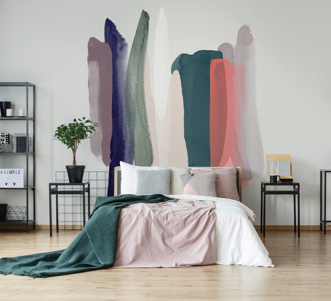 Modernes, helles Schlafzimmer mit einer abstrakten Fototapete mit Pinselstrichen, einem Bett mit Textilien und Metalltischen auf Holzboden.