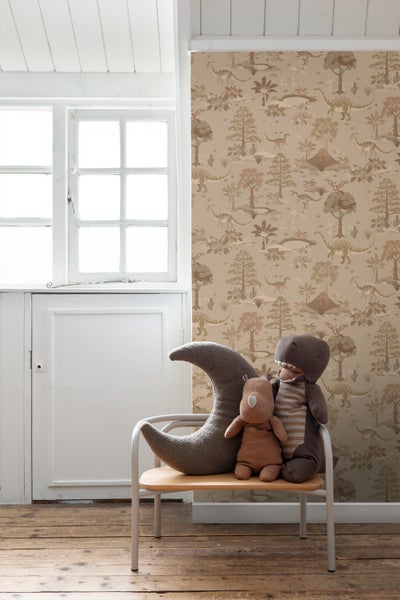 Kinderzimmer mit Tapete mit Dinosaurier Muster, dekoriert mit Stofftieren auf einem Stuhl